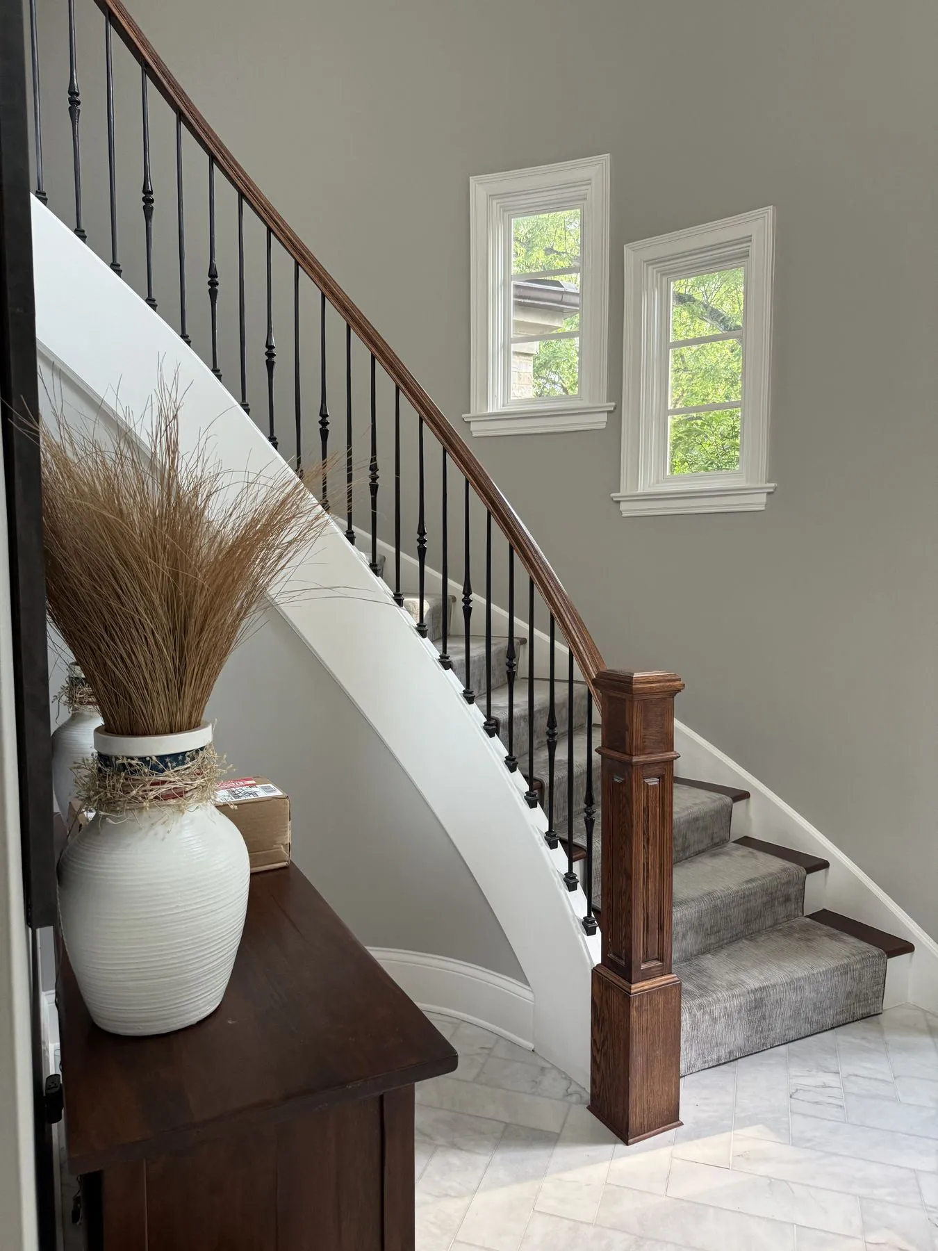 Curved staircase with an iron railing and fresh paint