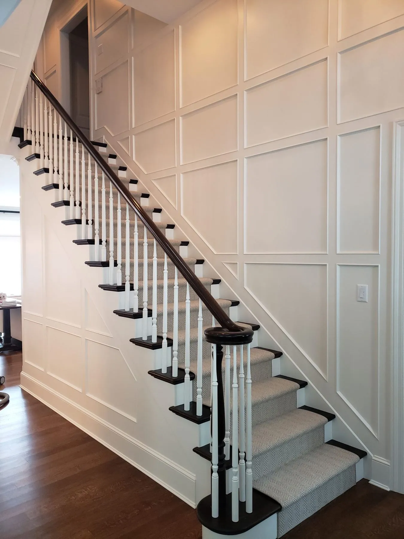 Staircase with floor-to-ceiling white wall paneling