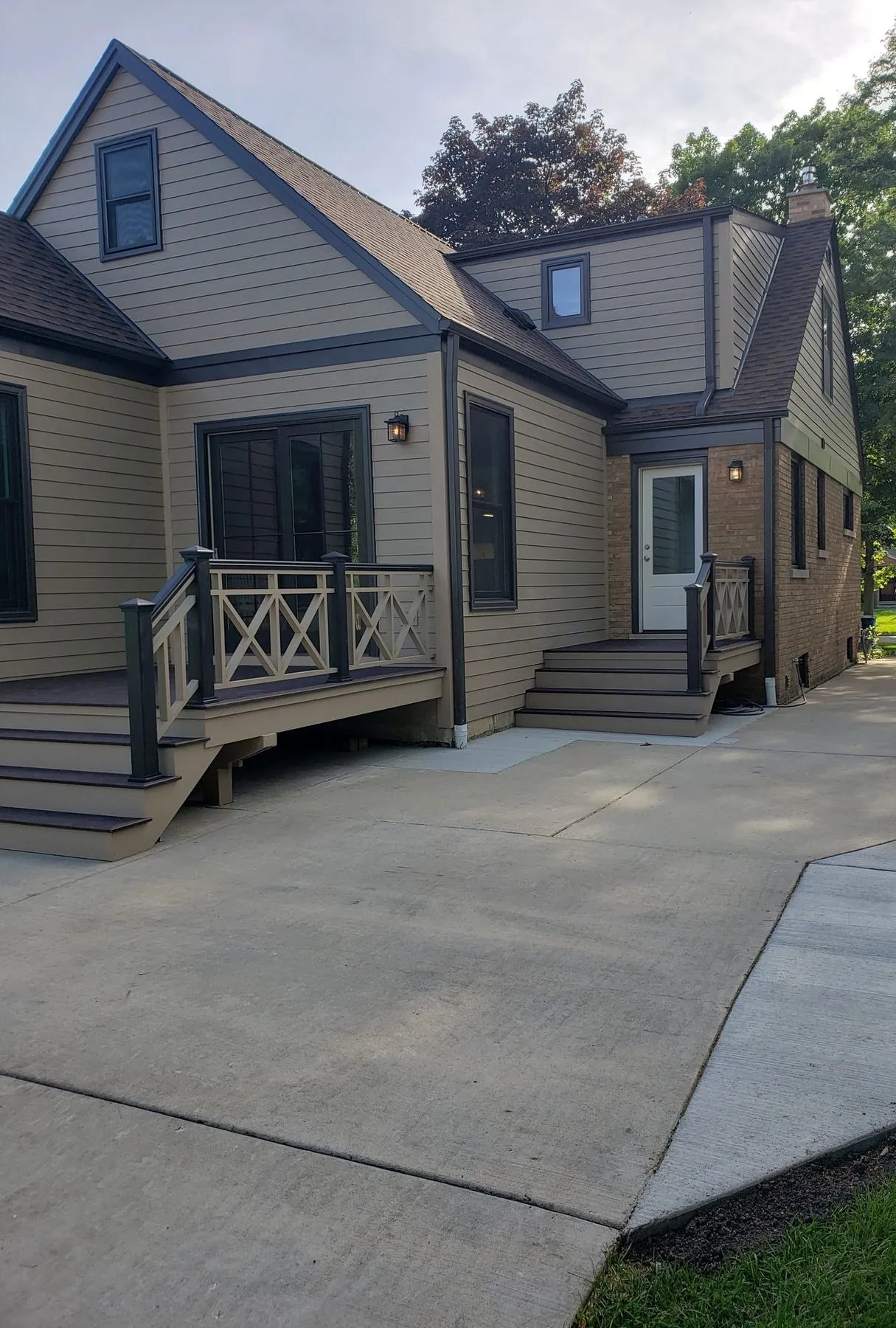 Rear of the addition with a deck and X-pattern railing